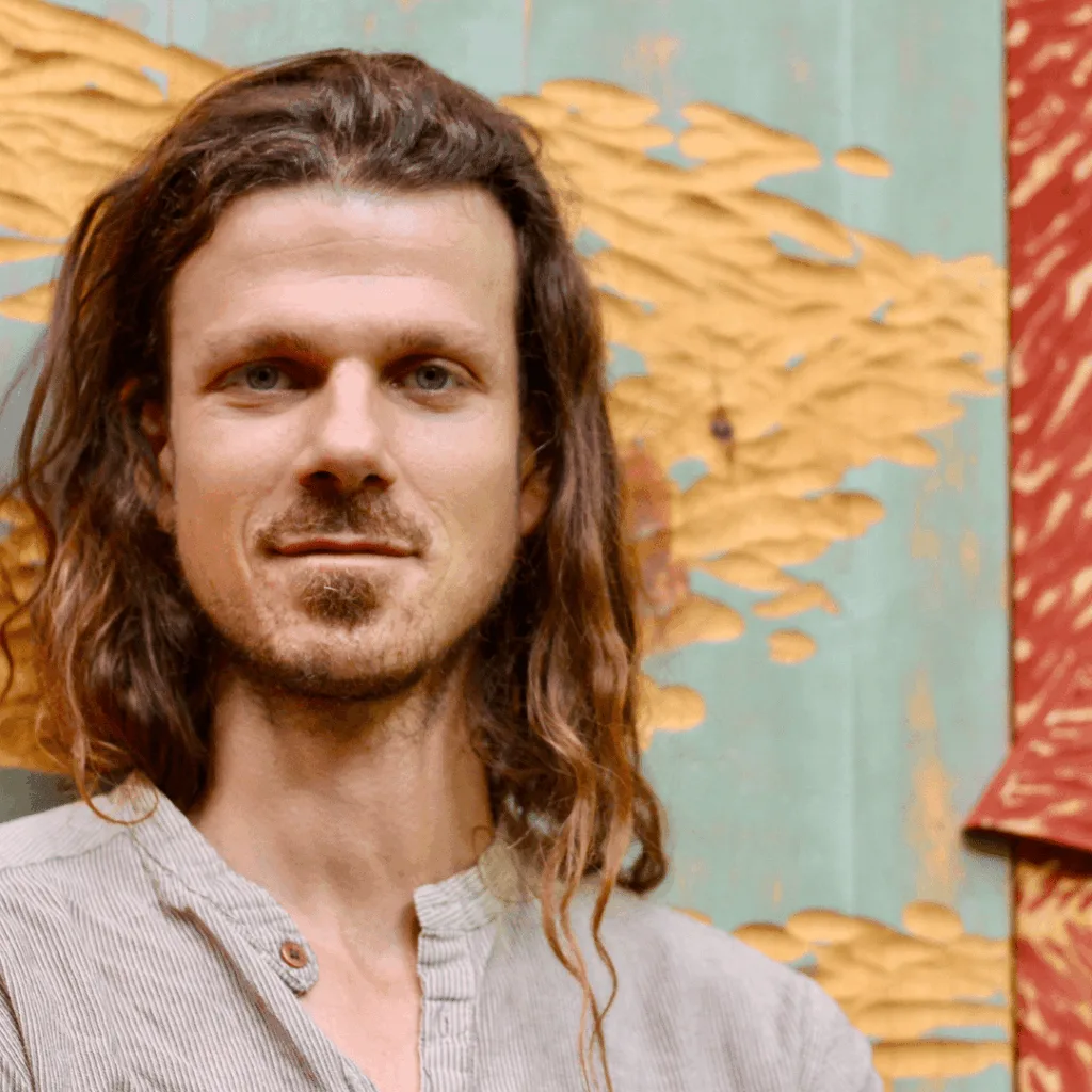 Creative Director of the Hudson Valley InterArts Eric Archer as he stands in front of his large scale wood carving.