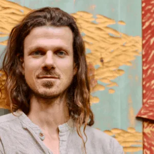 Creative Director of the Hudson Valley InterArts Eric Archer as he stands in front of his large scale wood carving.