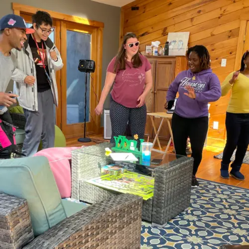 A group of diverse adults sing, dance and laugh as they enjoy a Musical Fun class inside the farmhouse at Cultivating Dreams.