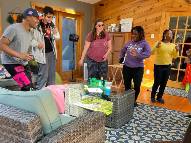 A group of diverse adults sing, dance and laugh as they enjoy a Musical Fun class inside the farmhouse at Cultivating Dreams.
