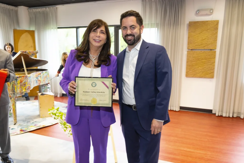 CEO Vicki Sylvester, PH.D. stands with Congressman Mike Lawler as she holds a certificate from the Brewster Chamber of Commerce during the Grand Opening of the Hudson Valley InterArts Center.