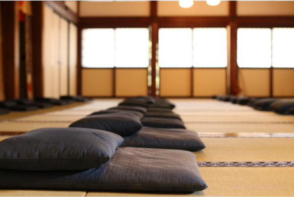 a peaceful meditation center, empty, with cushions awaiting meditators