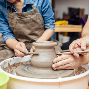 students learn to score a piece of work on a pottery wheel