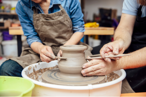 students learn to score a piece of work on a pottery wheel