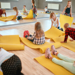 Group of children preparing for yoga class in the dance studio.