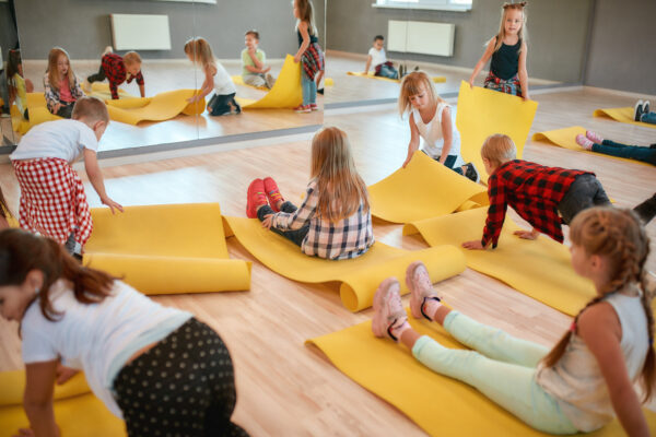 Group of children preparing for yoga class in the dance studio.