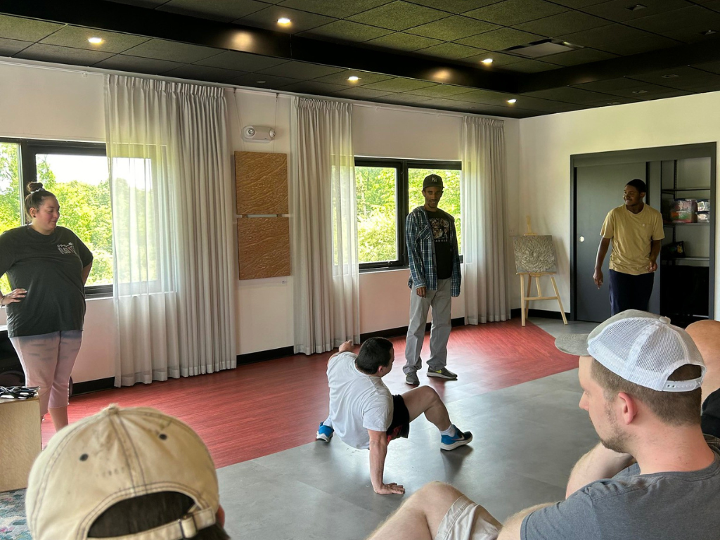 A student break dances as teacher Annie Ayala and students cheer him on at Hudson Valley InterArts