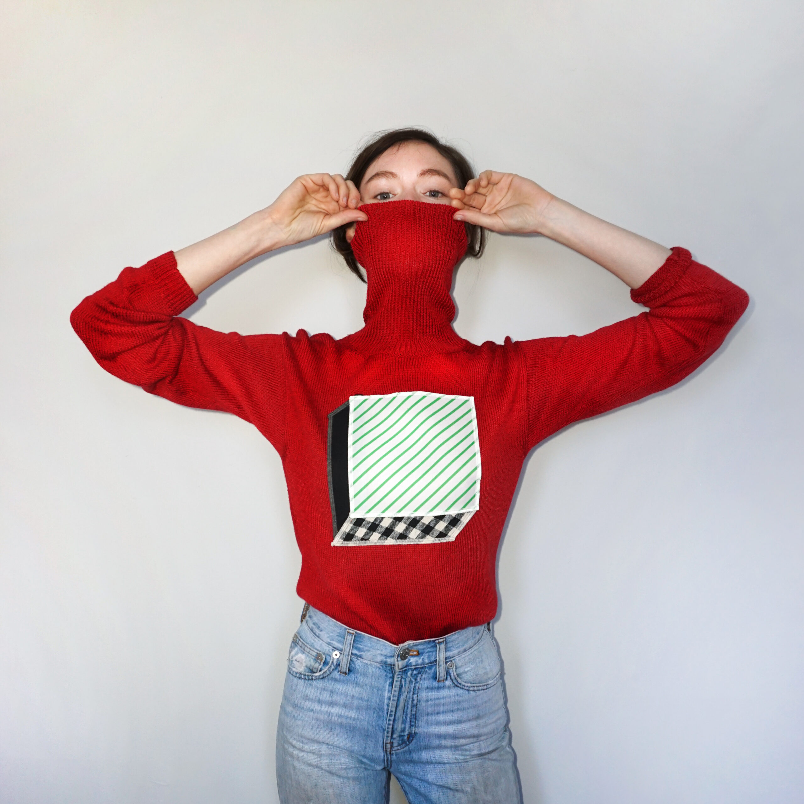 a bright red vintage sweater with a 3d cube on it