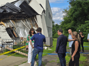 CEO Vicky Sylvester and Congressman Mike Lawler along with others stand in from of the proposed Universal Pre-K site after storm damage.